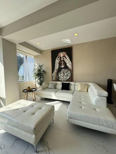a living room with two white couches and a painting at Espectacular depto en Santa Fe in Mexico City