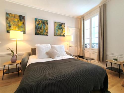 une chambre avec un lit avec deux tables et deux lampes dans l'établissement Saint Lazare 2 chambres Spacieux Modulable Confort, à Compiègne