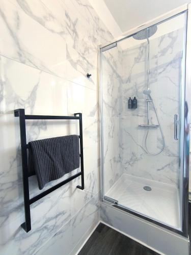 une salle de bain avec une douche avec une porte vitrée dans l'établissement Saint Lazare 2 chambres Spacieux Modulable Confort, à Compiègne