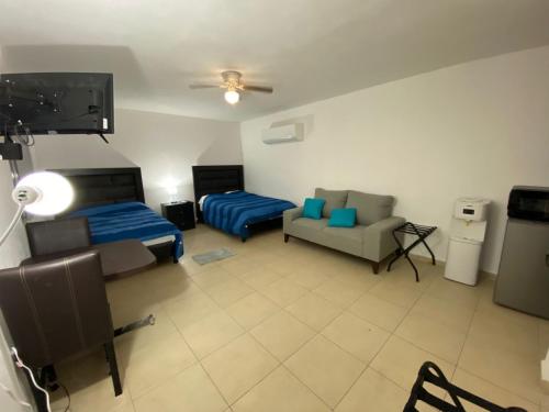 a room with two beds and a tv and a couch at Apartamentos Amplios Alfa # 238 in Monterrey
