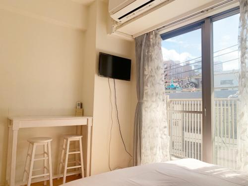 东京Ikebukuro Center! Ikebukuro 6min walk! 池袋中心地带! 池袋车站步行6分! 公寓干湿分离! 智能马桶! 高速无限制网路!Autolock302的一间卧室设有一张床和一个阳台的窗户。