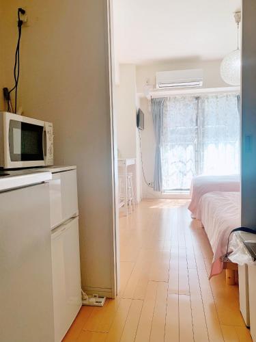 a bedroom with a bed and a microwave on a counter at Ikebukuro Center! Ikebukuro 6min walk! 池袋中心地带! 池袋车站步行6分! 公寓干湿分离! 智能马桶! 高速无限制网路!Autolock302 in Tokyo