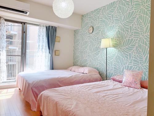 a bedroom with two beds and a wall mural at Ikebukuro Center! Ikebukuro 6min walk! 池袋中心地带! 池袋车站步行6分! 公寓干湿分离! 智能马桶! 高速无限制网路!Autolock302 in Tokyo