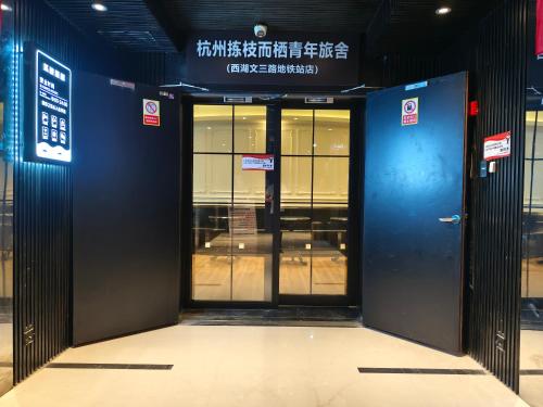 una entrada a un edificio con una puerta azul en Hangzhou Jianzhi Erqi Youth Hostel Xihu Branch, en Hangzhou