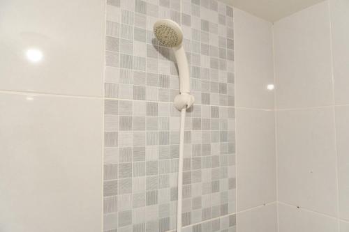 a shower with a shower head in a bathroom at Modern Look 2BR Tokyo Riverside PIK 2 Apartment By Travelio in Rawalembang