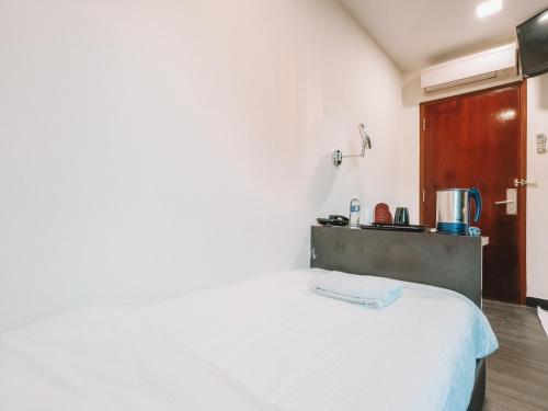 a bedroom with a white bed in a room at A Hotel Desker in Singapore