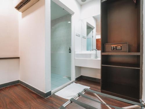 a glass shower in a bathroom with a sink at A Hotel Desker in Singapore