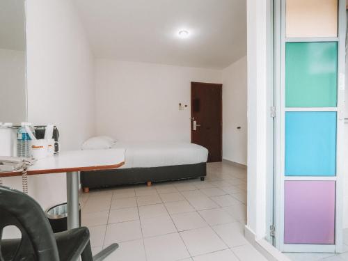 a room with a bed and a desk and a table at A Hotel Desker in Singapore
