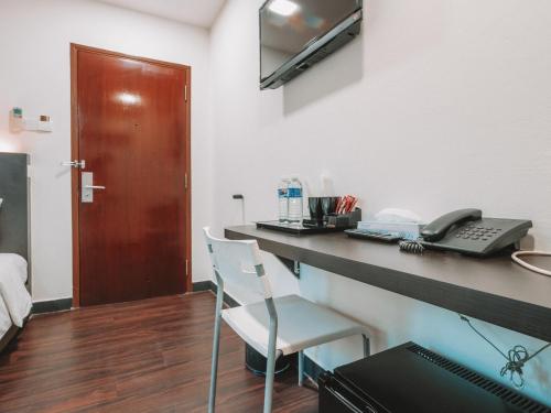a room with a desk with a phone and a phone at A Hotel Desker in Singapore