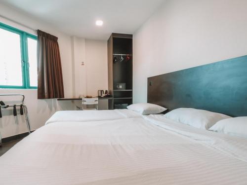a bedroom with two beds and a green wall at A Hotel Desker in Singapore