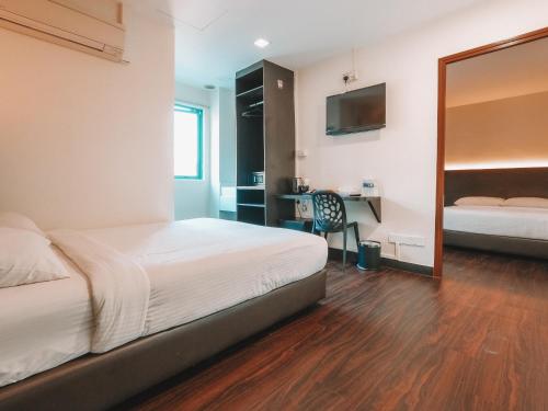 a bedroom with a bed and a desk and a mirror at A Hotel Desker in Singapore