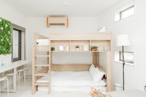 a room with bunk beds and a desk at Momo-stay Ikebukuro in Tokyo