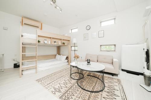 a white living room with a table and a couch at Momo-stay Ikebukuro in Tokyo