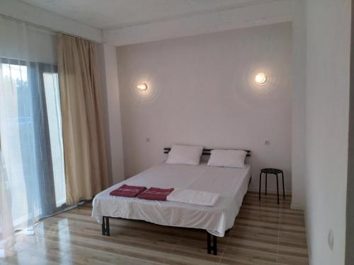 a white bedroom with a bed with two pillows at Bambuki in Kuchkisabano