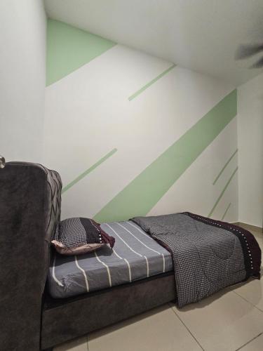 a bed in a room with a green and white wall at Bayu Temiang Residence - Cityscape Haven in Seremban