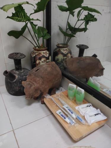 a table with toothbrushes and vases and a cutting board at GRHA PAWITRA TROWULAN in Trowulan