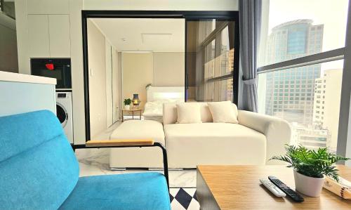 a living room with a white couch and a large window at Majestic Seoul Stay Central in Seoul