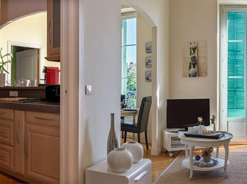 a kitchen with a living room with a table at Aston - Appartement Centre Ville Massena in Nice