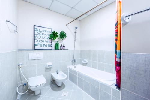 a bathroom with a toilet and a tub and a sink at Stylish 1BR Apartment! Near Metro & Stroll to Dubai Marina in Dubai