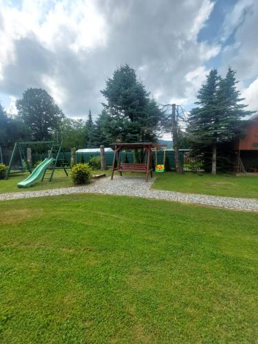 a park with a playground with a swing at Pod akacjami in Baligród