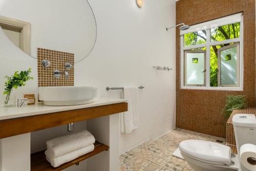 une salle de bain avec un lavabo et des toilettes dans l'établissement Neighbourgood Romney, au Cap