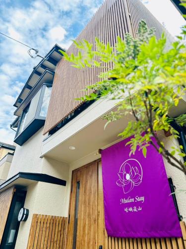 a purple sign on the side of a building at Mulan Stay 嵯峨嵐山 in Shimo saga