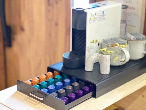 a tray of colored candles on a counter next to a coffee maker at Mulan Stay 嵯峨嵐山 in Shimo saga