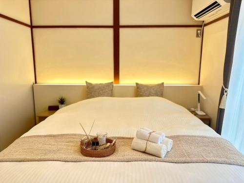 a bed with two towels and a basket on it at Mulan Stay 嵯峨嵐山 in Shimo saga