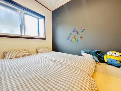 a bedroom with two beds and a window and a toy at Mulan Stay 嵯峨嵐山 in Shimo saga