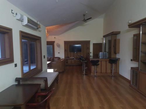 a large living room with wooden floors and a kitchen at Tropical Blooms by StayApart in Kutta