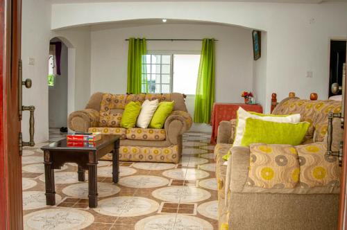 a living room with two couches and a table at Veronica Villa 68 in Lucea