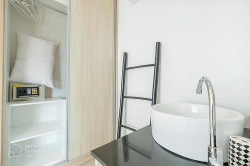 a bathroom with a sink and a clock on a counter at The Wings Boutique Hotels Krabi Ko Lanta in Ko Lanta