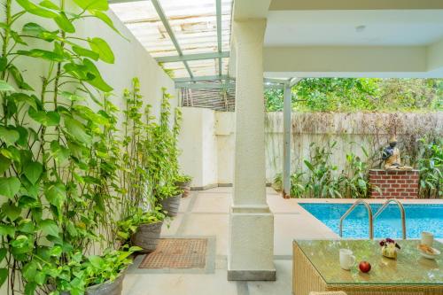 an indoor garden with a pool and plants at ELIVAAS 3 BHK Pool & Bar - Villa Judiline in Goa