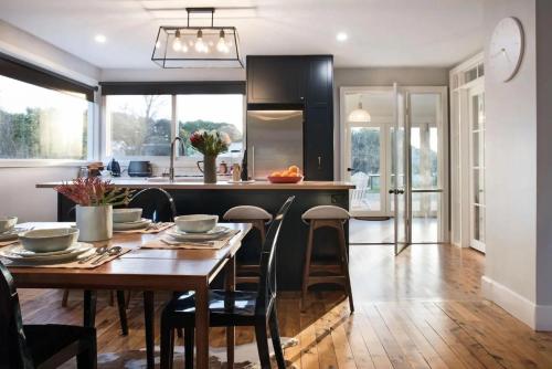 a kitchen with a wooden table and a dining room at The Arlow House in Daylesford