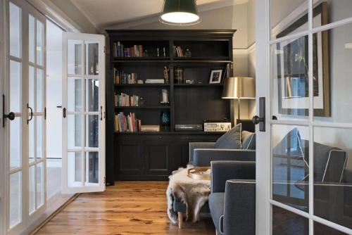 a living room with a couch and a book shelf at The Arlow House in Daylesford
