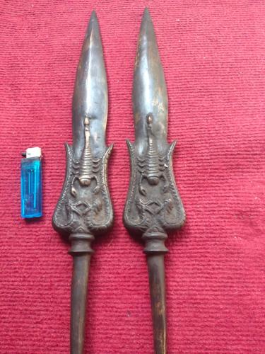 two old metal utensils sitting on a red surface at GRHA PAWITRA TROWULAN in Trowulan