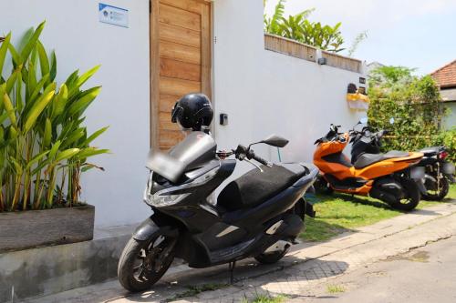 two motorcycles are parked next to a building at Peacock Private Pool Paradise in Dalung
