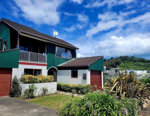 a house with a green and white at Esplanade Townhouse in Gisborne