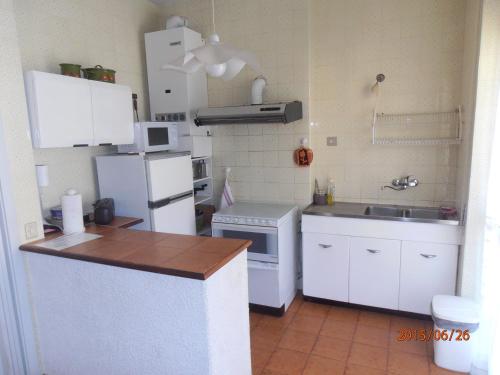a kitchen with a white refrigerator and a sink at Casa Monteprato in Zoagli
