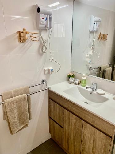 a bathroom with a sink and a mirror at Jolly Swagman Motor Inn Euroa in Euroa