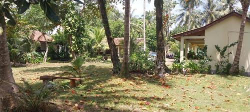 a house in the middle of a yard with trees at Kambuna Bungalow in Krui