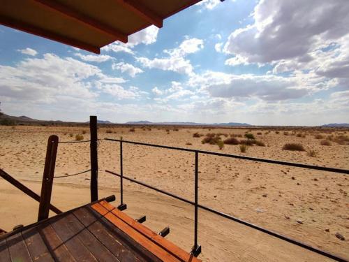 a view of the desert from the porch of a house at Camp Gecko - PRIVATE NATURE RESERVE; TENTED CAMP AND CAMPSITE in Solitaire