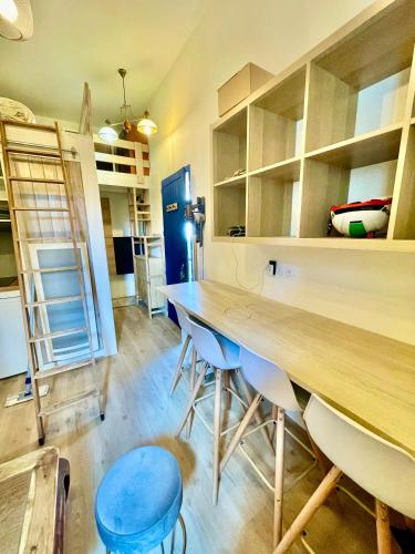Cette chambre comprend une grande table et des chaises en bois. dans l'établissement proche kedge et universitée appartement cosy avec parking ,cuisine équipée ,sdb et jardin, à Talence