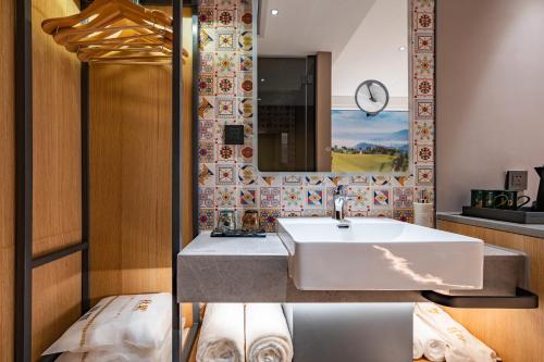 a bathroom with a sink and a mirror at Qiuguo Hotel Beijing Convention Center Bird's Nest Beiyuan in Beijing