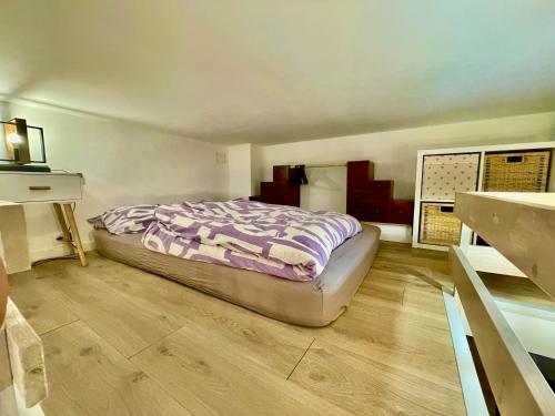 une chambre avec un lit et un parquet dans l'établissement proche kedge et universitée appartement cosy avec parking ,cuisine équipée ,sdb et jardin, à Talence