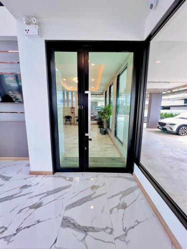 a hallway with glass doors in a building at เวลโกรว์ โฮเทล - Wellgrow Hotel in Ban Bang Kha