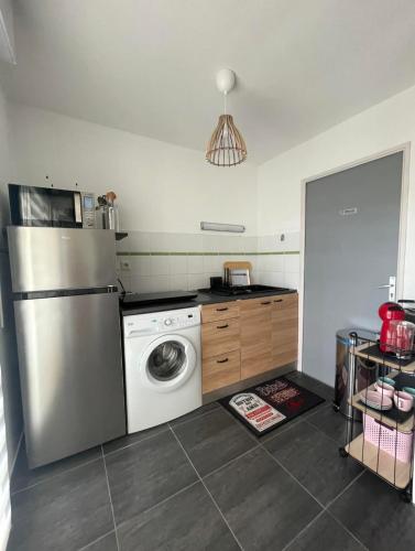 une cuisine avec un réfrigérateur et une machine à laver dans l'établissement Yoyo's appart, à Perpignan