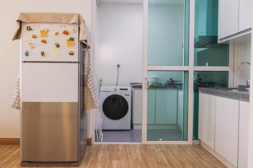 a kitchen with a refrigerator with magnets and a washing machine at NaiBnB in Impiria Residensi in Klang