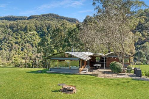 a house in the middle of a field at Kangaroo River Hideaway, Kangaroo Valley in Upper Kangaroo River