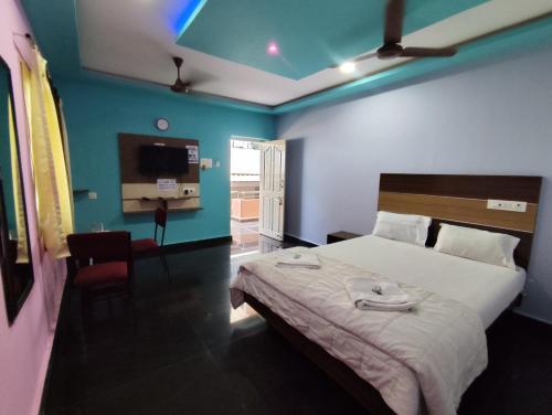 a bedroom with a bed and a room with a tv at Sri Murugan Beach Paradise Hotel in Mahabalipuram